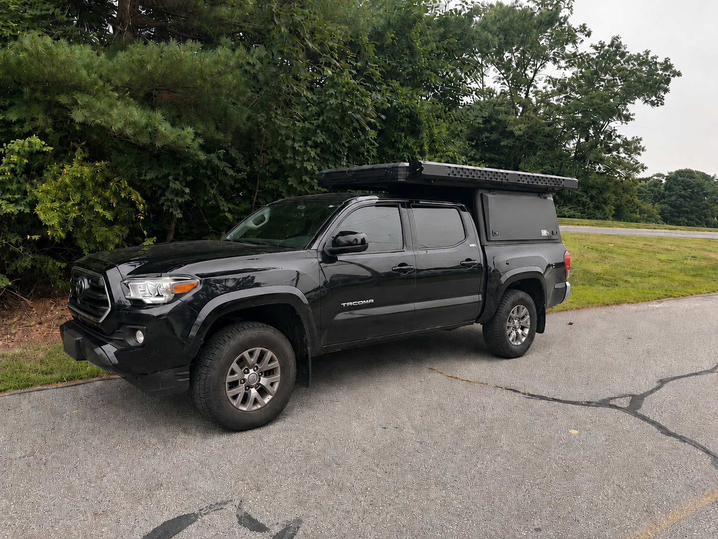 Toyota Tacoma with pop-up truck bed camper at trailhead